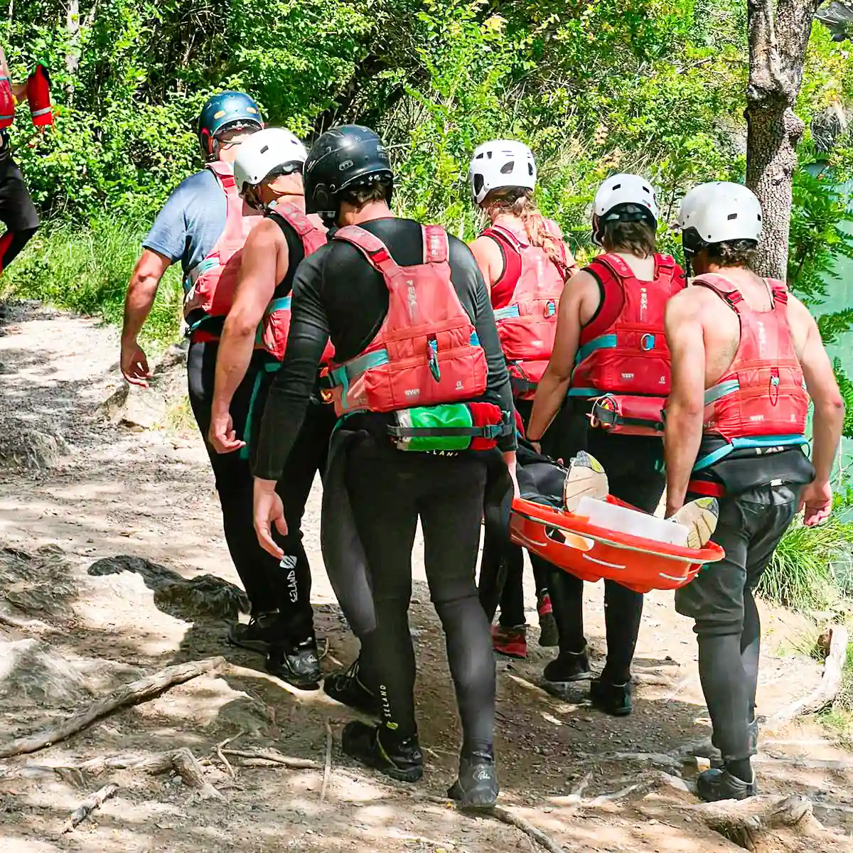 Guias moviendo una camilla para hacer prácticas de rescate en aguas bravas